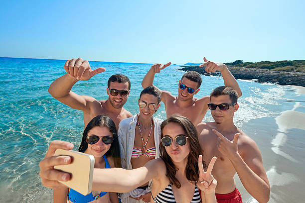 istock Young people taking self portrait on beach 612019620