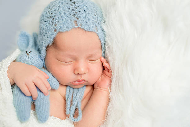 istock sleepy newborn boy in blue hat 612020322