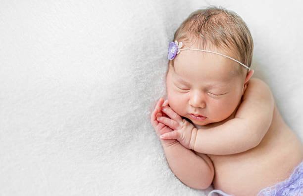 istock lovely newborn girl sleeping with hands under head, top view 612020800