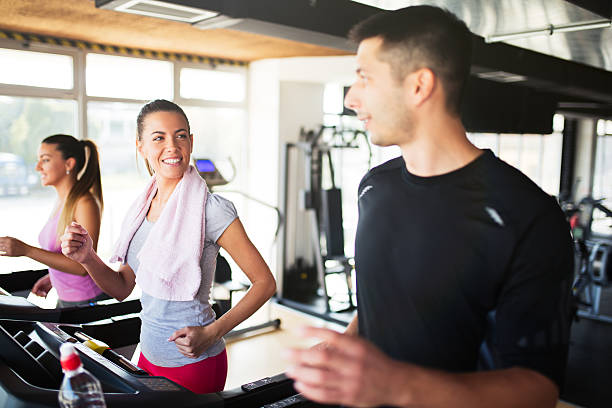 istock Side view of  three people doing cardio on treadmills. 612022288