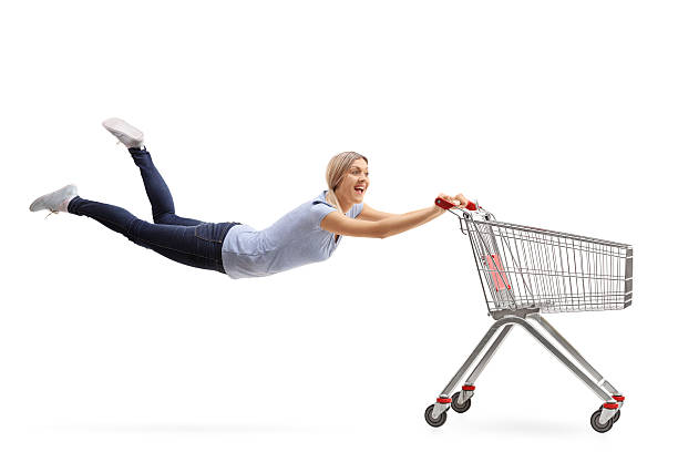 istock Woman being pulled by an empty shopping cart 612023690