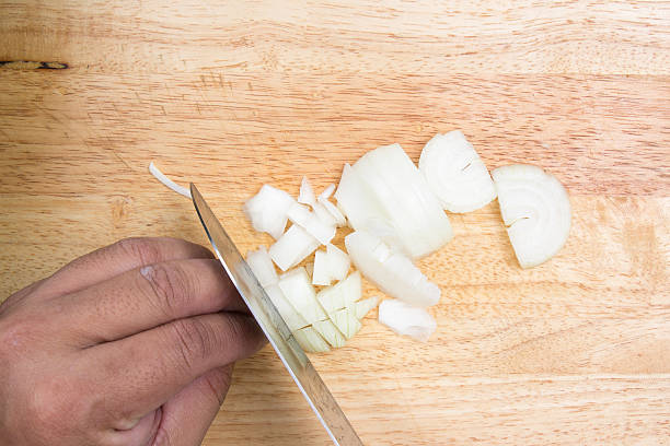 istock Chef slicing onion on wooden broad 612025756