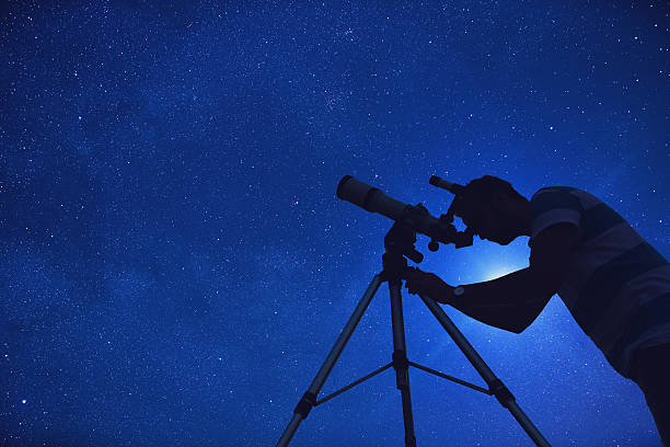 istock Man looking at the stars through a telescope. 612026458