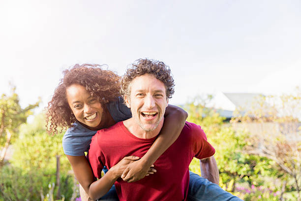 istock Happy man piggybacking girlfriend in yard 612026462