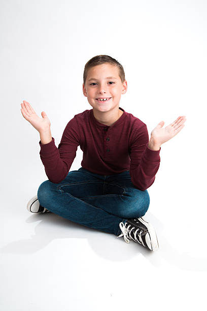 Boy sitting with hands open stock photo