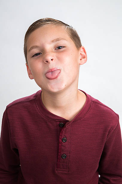 Silly boy with tongue out - close up stock photo