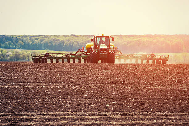 тракторное вспашка фермерского поля в рамках подготовки к весенней посадке. - высаживать средство передвижения стоковые фото и изображения