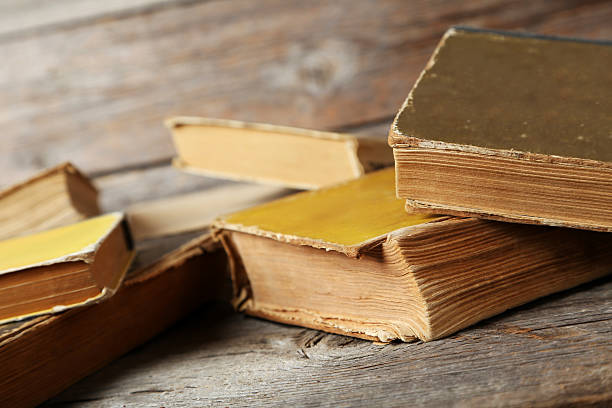 istock Old antique books on grey wooden table 612031630