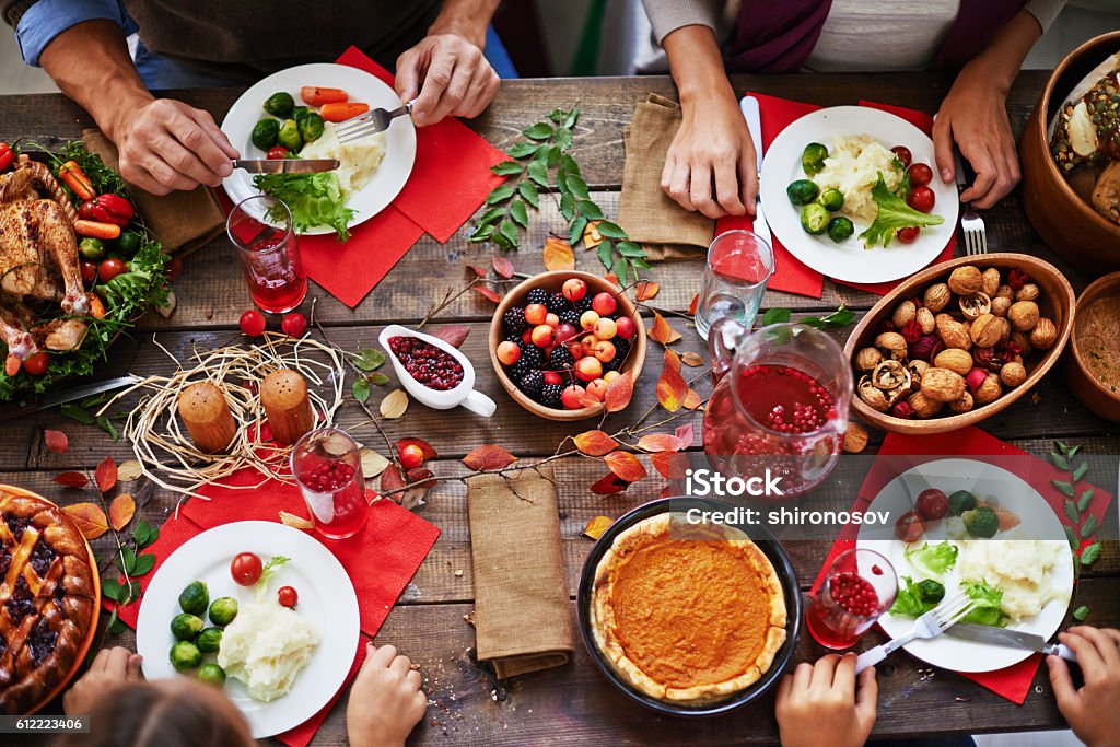 Thanksgiving feast Above view of thanksgiving dinner and family eating at table Thanksgiving - Holiday Stock Photo