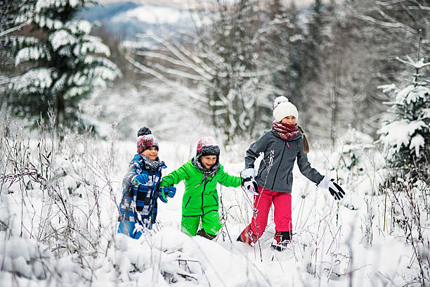 istock Happyt children running in winter forest 612228058