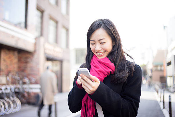 istock Woman using smartphone in street 612228192
