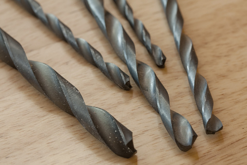 Detail of used drill bits on a piece of wood.