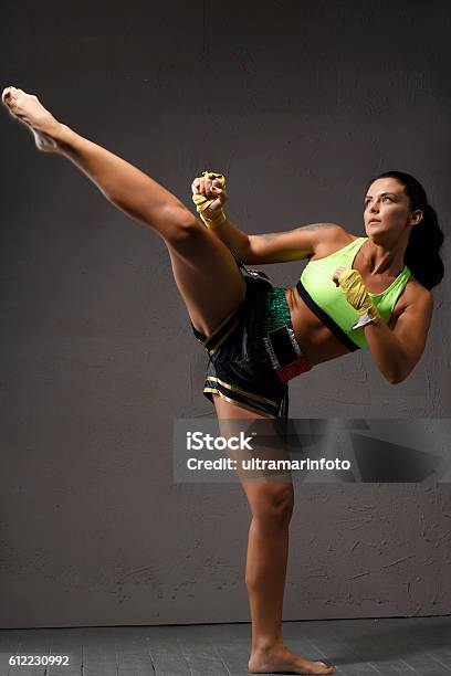 Photo libre de droit de Kickboxing Féminin Combattante Athlétique Coups De Pied Formation Sportive banque d'images et plus d'images libres de droit de Femmes