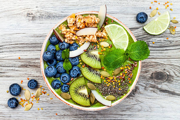Matcha green tea breakfast superfoods smoothies bowl with chia seeds Matcha green tea breakfast superfoods smoothies bowl topped with chia, flax and pumpkin seeds, bee pollen, granola, coconut flakes, kiwi and blueberries. Overhead, top view, flat lay oat crop photos stock pictures, royalty-free photos & images