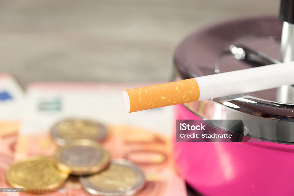 Money, cigarette and an ash cup Euro money, cigarette and an ashtray Addiction Stock Photo