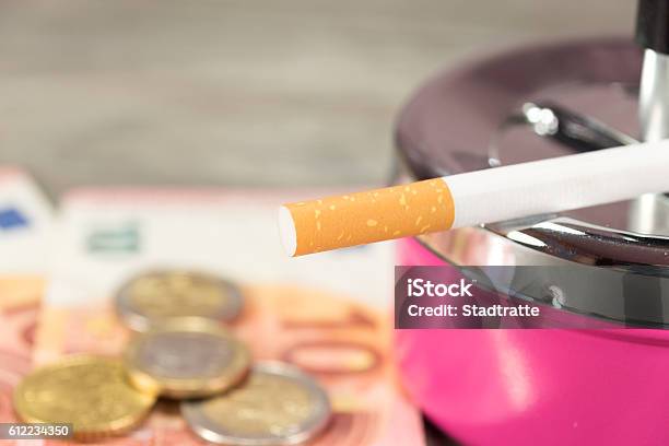 Money Cigarette And An Ash Cup Stock Photo - Download Image Now - Addiction, Ashtray, Cigarette