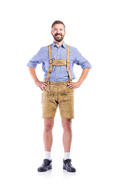 Man in traditional bavarian clothes, hands on hips Handsome young man in traditional bavarian clothes, hands on hips. Beer Fest. Studio shot on white background, isolated. Lederhosen stock pictures, royalty-free photos & images