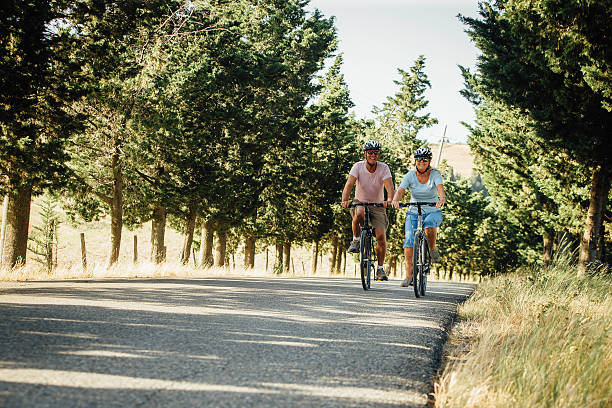 coppia matura in bicicletta in toscana - mature adult bicycle senior adult heterosexual couple foto e immagini stock