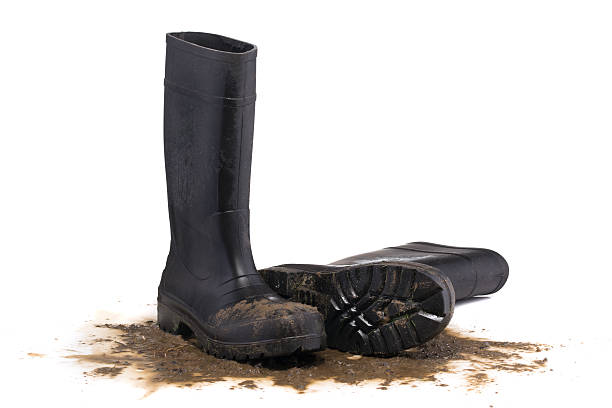 Muddy rubber fallen boots 3/4 view isolated on white background stock photo