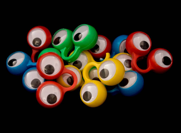 istock Multicoloured Funny Googly Eyes On Black Background 612237304