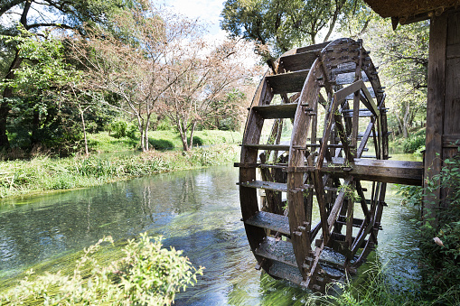 Ancient water wheel within serene and scenic river setting