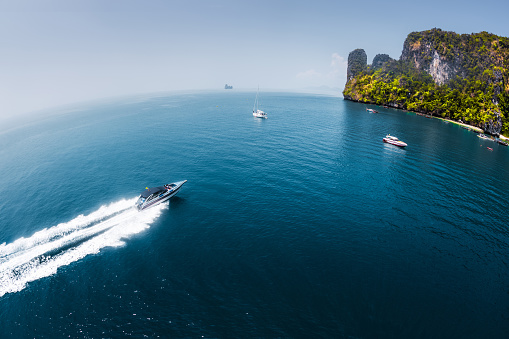 View of the island in Andaman sea with speedboat in a clear water, Thailand