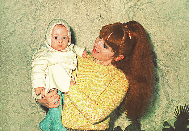 mãe segurando seu bebê fofo - 1960s style image created 1960s retro revival old fashioned - fotografias e filmes do acervo