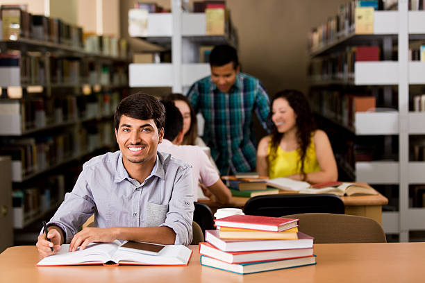 istock Handsome nepalese student at the library and smiling 612244346