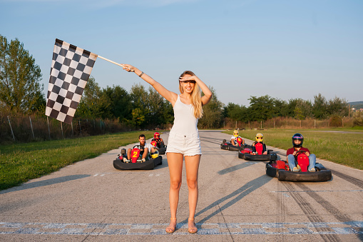 Friends at go karts at amusement park, ready for race