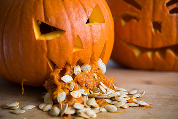 Pumpkin puking with pumpkin seeds on wood table Pumpkin puking with pumpkin seeds on wood table throwing up pumpkin stock pictures, royalty-free photos & images