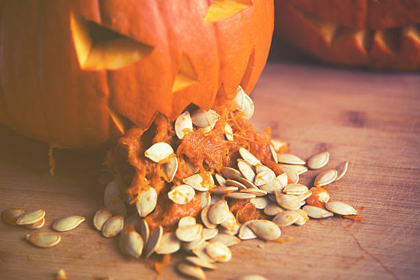 close up on Pumpkin puking with pumpkin seeds close up on Pumpkin puking with pumpkin seeds on wood table pumpkin throwing up stock pictures, royalty-free photos & images
