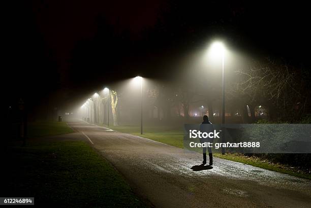 Single Person Walking On Street In The Dark Night Stock Photo - Download Image Now - Night, Loneliness, Street