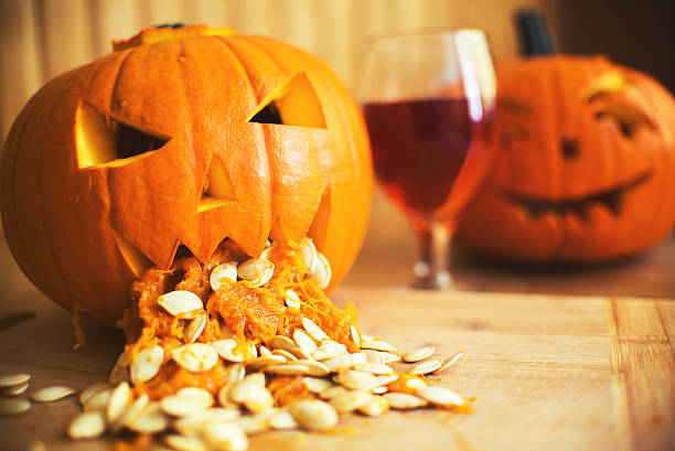 Pumpkin puking with pumpkin seeds on wood table Pumpkin puking with pumpkin seeds on wood table, glass of wine, vintage effect pumpkin throwing up stock pictures, royalty-free photos & images