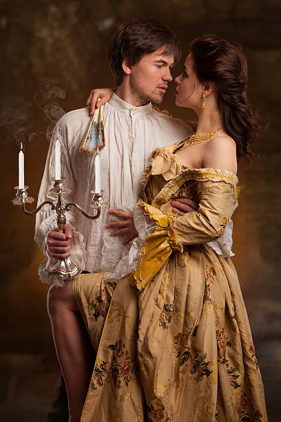 portrait of couple in historical costumes on dark background portrait of couple in historical costumes on dark background flirty stock pictures, royalty-free photos & images