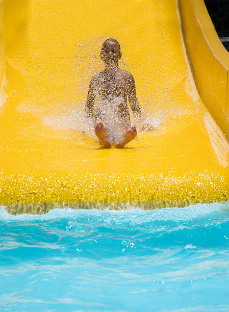istock Girl riding down the water slide 612249880