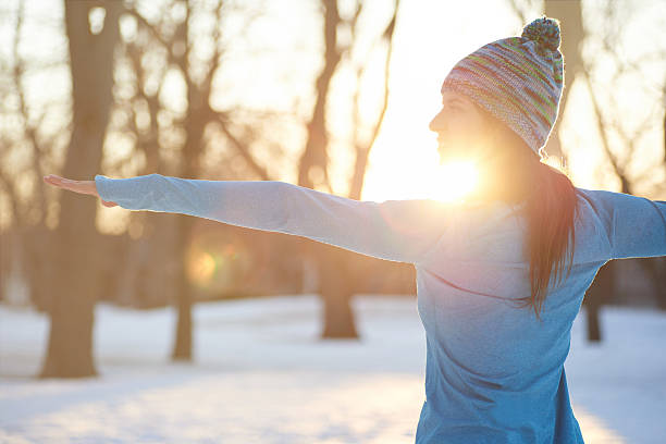 Attractive mixed race woman doing yoga in nature at winter stock photo