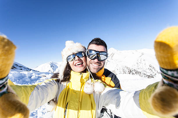alegres jóvenes esquiadores haciendo selfie en la montaña de nieve - skiing snow couple mountain fotografías e imágenes de stock