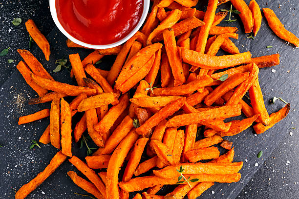 papas fritas de batata de naranja al horno caseras saludables con ketchup, hierbas - sweet potato french fries yam baked fotografías e imágenes de stock