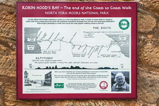 Robin Hoods Bay,England - July 11, 2016:map showing the route of the 192 mile coast to coast walk, made famous by Alfred Wainwright, beginning at St Bees Head Cumbria on England's west coast and ending at Robin Hoods Bay on the east coast, with a photograph of Wainwright 