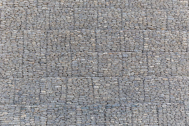 istock The wall of river stones packed in a metal grid 612252932
