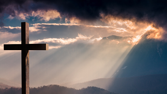 Cruz de madera de Jesucristo en una dramática y colorida puesta de sol photo