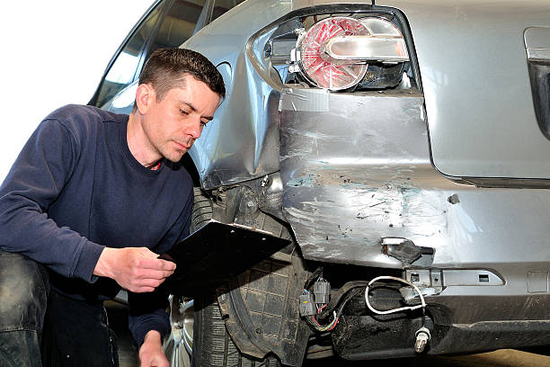 mécanicien inspectant la carrosserie d’une voiture à la station-service de l’atelier de réparation automobile - car inspector examining failure photos et images de collection