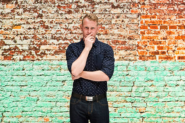istock Sad man in front of brick wall 612254330