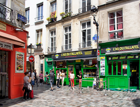Paris, France - July 8, 2016: Fallafel places in Jewish quarter of Le Marais district in Paris. People have street food.