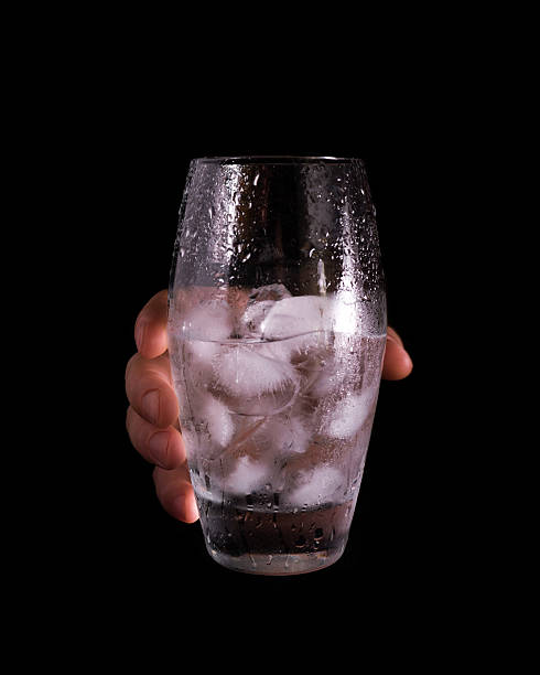 Hand holding glass with water and ice