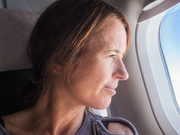 istock Woman is looking through a window in the aircraft. 612258910