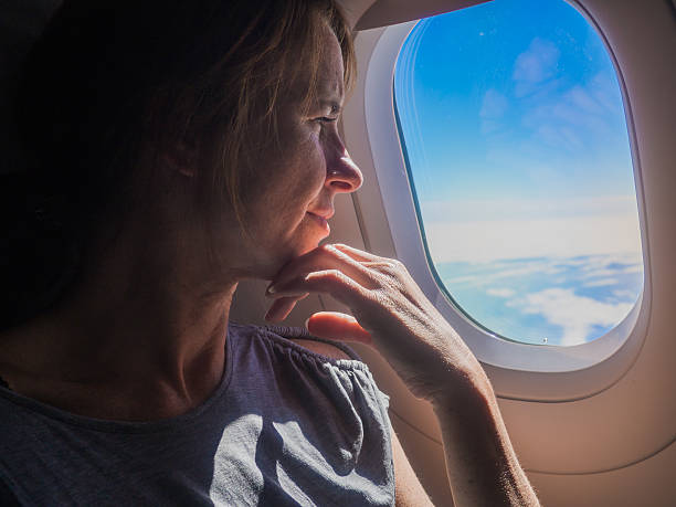 istock Woman is looking through a window in the aircraft. 612259254