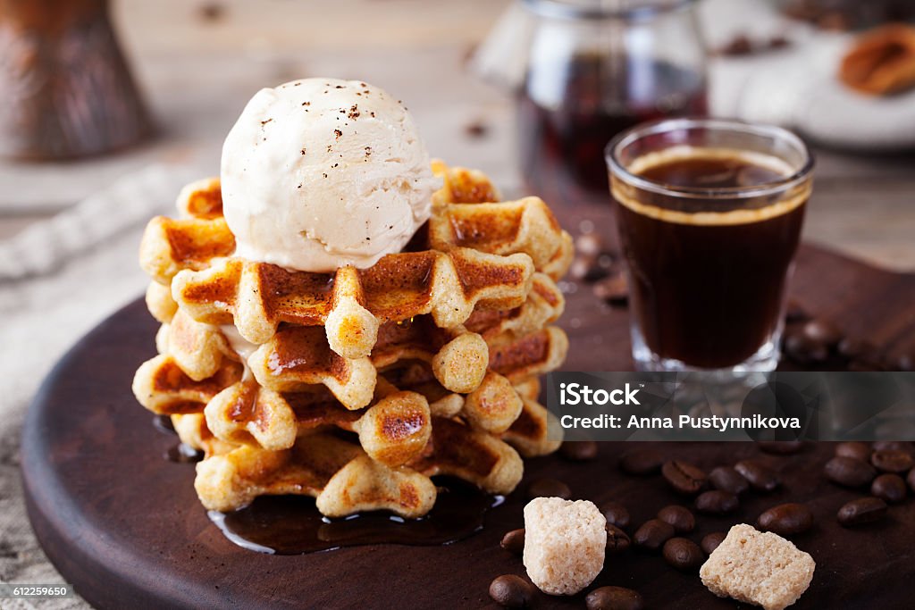 Fresh whole wheat waffles, ice cream, maple syrup Fresh whole wheat waffles with ice cream, maple syrup and coffee on a wooden background Cafe Stock Photo