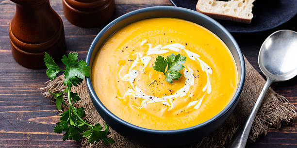 パンプキン、キャロットスープにクリーム色とパセリ - thanksgiving vegetarian food pumpkin soup ストックフォトと画像