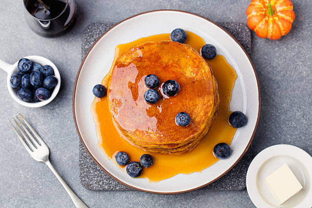 zucca pancake con sciroppo d'acero e mirtilli su un piatto. - honey caramel syrup fruit foto e immagini stock